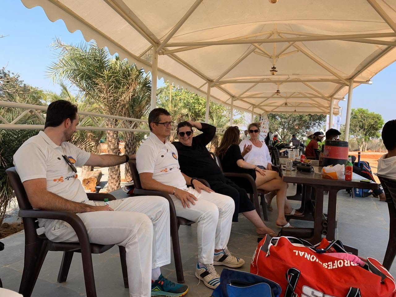 Players and supporters relaxing in the shade watching the cricket in India